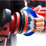 Person holding a red and black power buffer with a blue polishing pad.